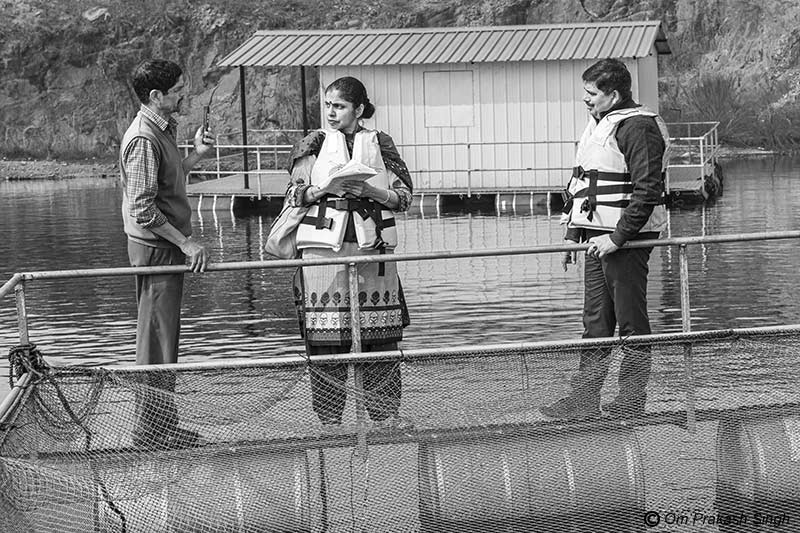 Nandita Singh from Södertörn University, Stockholm, Sweden in conversation with a SHG member and the District Fisheries Officer at the cage fish unit in mining pit in Nandna village, Dumka district, Jharkhand